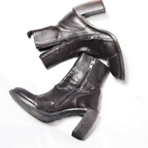 Top view of pair of dark brown leather boots with zipper and wide high heels placed on white background